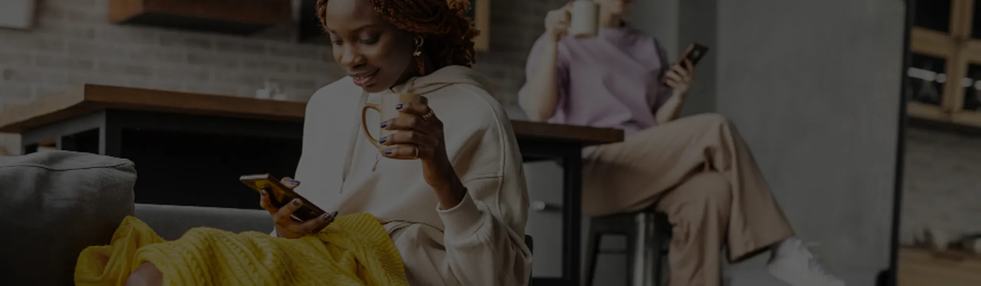 Customer holding a smartphone while drinking beverage in a casual setting